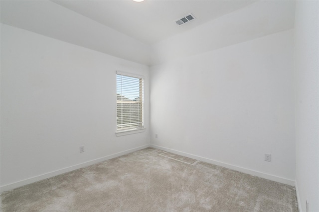 empty room with light carpet, visible vents, and baseboards