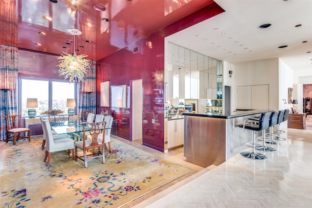 kitchen featuring white cabinetry, light parquet flooring, and a towering ceiling