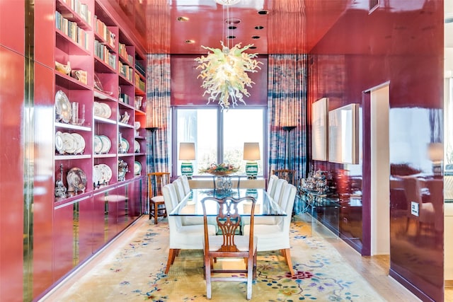 dining space featuring hardwood / wood-style flooring, built in shelves, and a notable chandelier