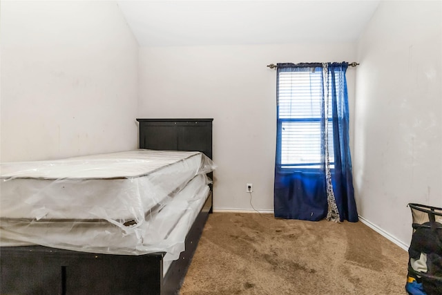 carpeted bedroom with lofted ceiling