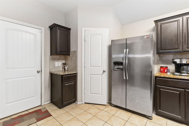 kitchen featuring light tile patterned floors, backsplash, dark brown cabinetry, and stainless steel fridge with ice dispenser