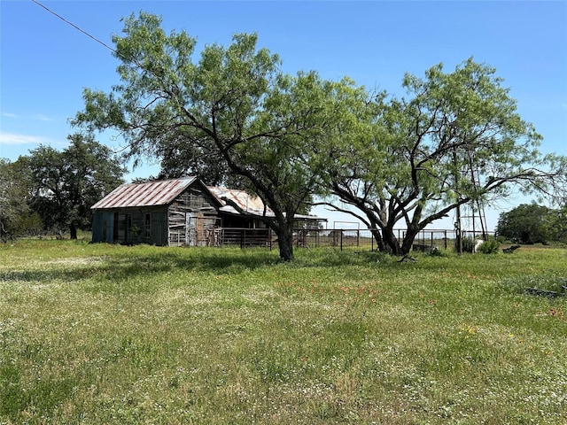 view of yard featuring an outdoor structure and a rural view