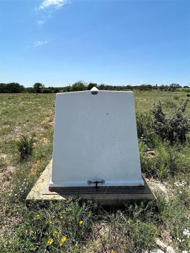 entry to storm shelter featuring a rural view