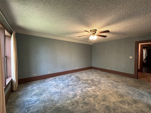 carpeted spare room featuring ceiling fan and a textured ceiling