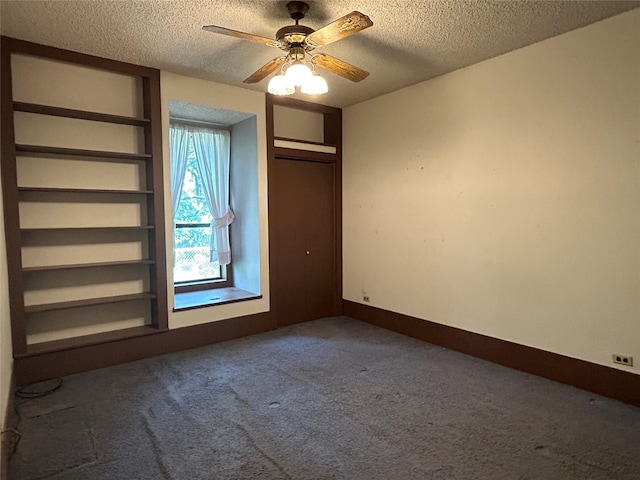 carpeted empty room with ceiling fan and a textured ceiling