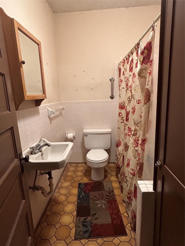 bathroom with sink, tile walls, tile patterned flooring, a textured ceiling, and toilet