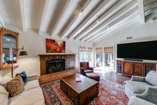 living room featuring beamed ceiling, a brick fireplace, and high vaulted ceiling