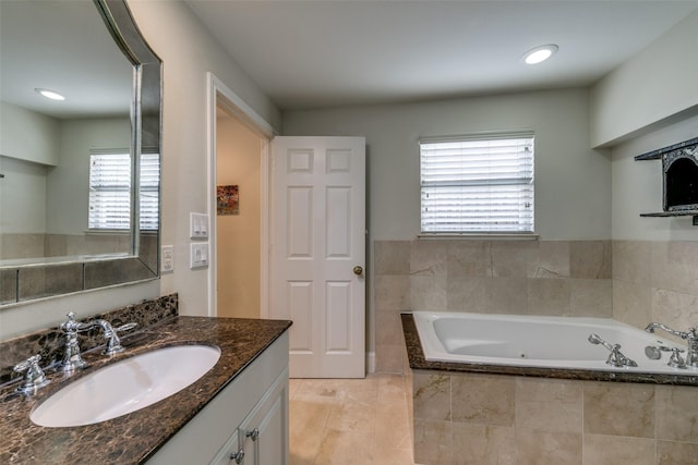 bathroom with vanity and a relaxing tiled tub