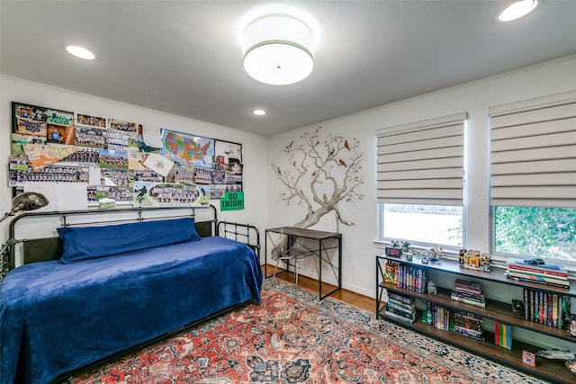 bedroom with crown molding and hardwood / wood-style floors