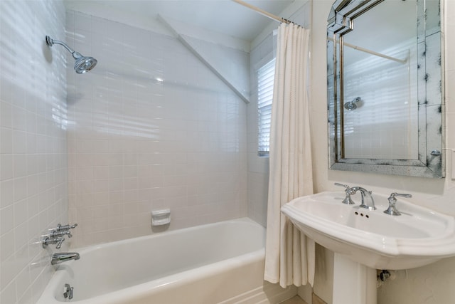 bathroom featuring shower / tub combo with curtain and sink