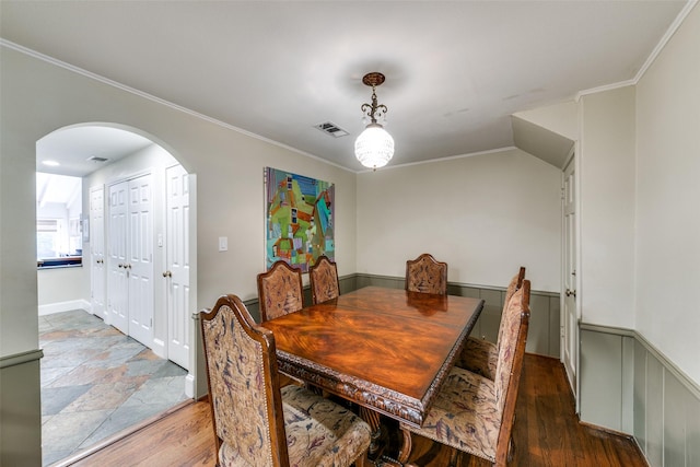 dining area with crown molding and dark wood-type flooring