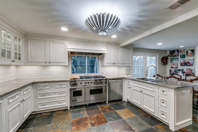 kitchen featuring tasteful backsplash, sink, white cabinets, kitchen peninsula, and stainless steel appliances