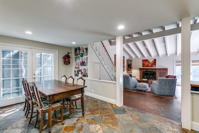 dining space featuring french doors, a healthy amount of sunlight, and vaulted ceiling with beams