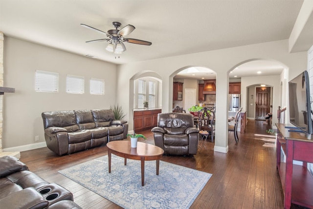 living room with ceiling fan and dark hardwood / wood-style flooring