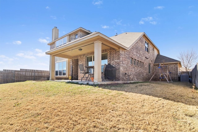 rear view of house featuring a lawn and a patio