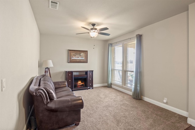 living area with ceiling fan and carpet floors