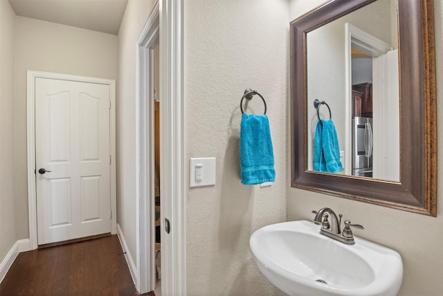 bathroom featuring sink, wood-type flooring, and washer / clothes dryer