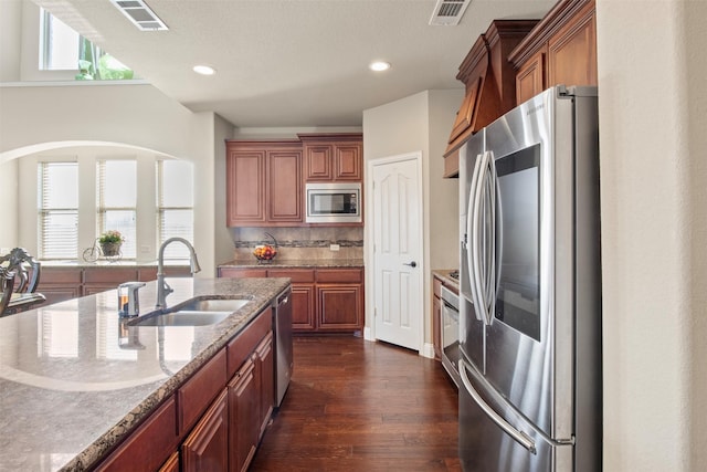 kitchen featuring light stone counters, sink, a healthy amount of sunlight, and appliances with stainless steel finishes