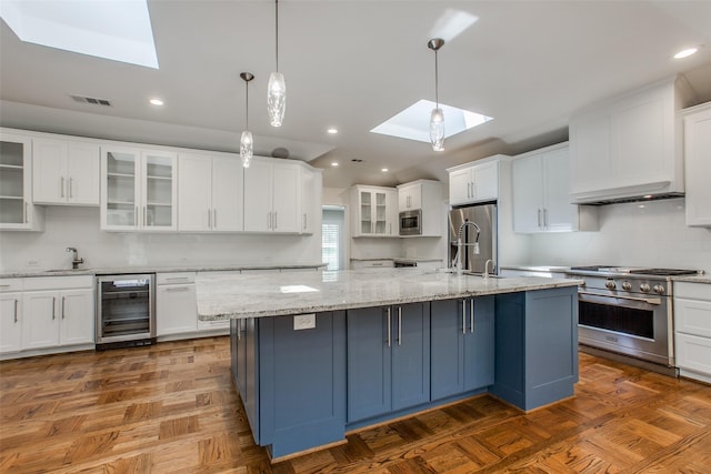 kitchen featuring wine cooler, white cabinetry, pendant lighting, and stainless steel appliances