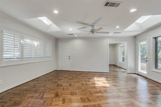 spare room with ornamental molding, a skylight, dark parquet floors, and ceiling fan