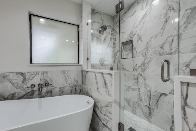 bathroom featuring tile walls and shower with separate bathtub