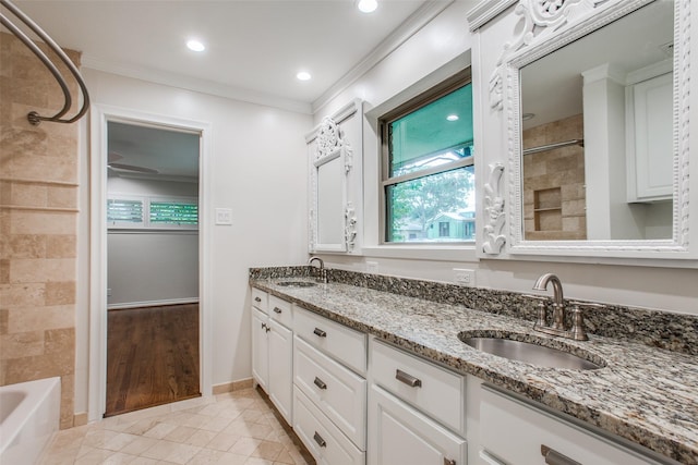 bathroom with crown molding, tiled shower / bath, vanity, and tile patterned flooring