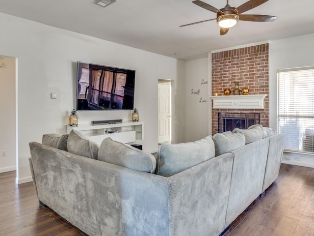 living room featuring dark hardwood / wood-style floors, ceiling fan, and a fireplace