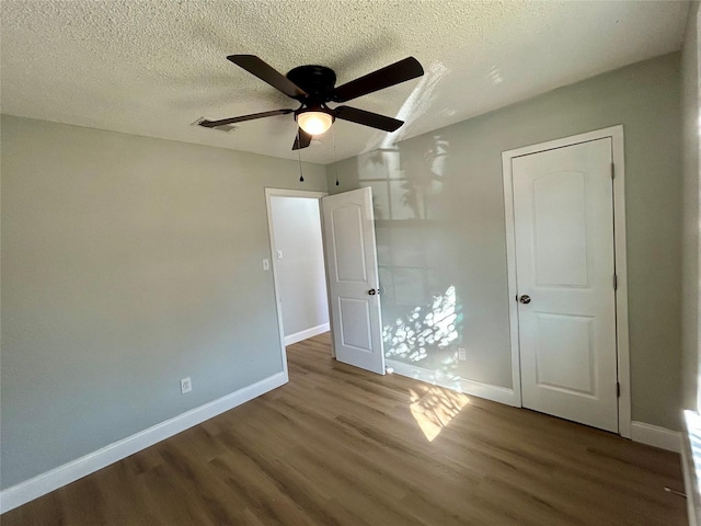 unfurnished bedroom with hardwood / wood-style floors, a textured ceiling, and ceiling fan