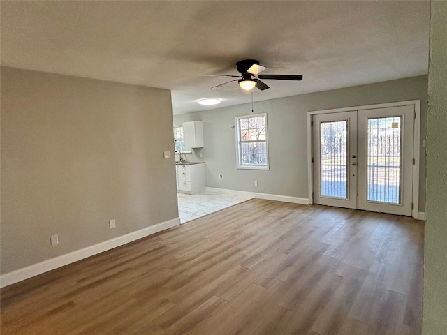 unfurnished living room featuring light hardwood / wood-style floors, french doors, and ceiling fan