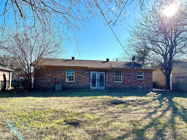 rear view of property featuring a yard and central air condition unit