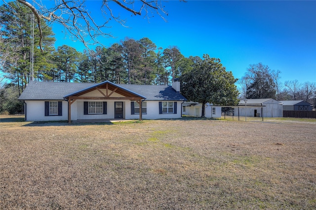 single story home with a front yard and a storage unit