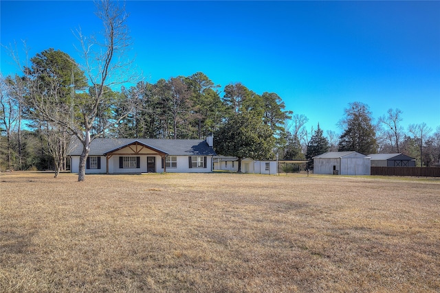 view of front of property featuring a front yard and a shed