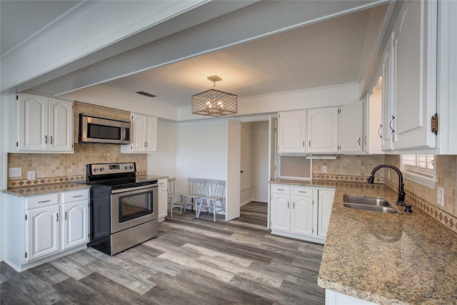 kitchen featuring sink, appliances with stainless steel finishes, light stone counters, tasteful backsplash, and white cabinets