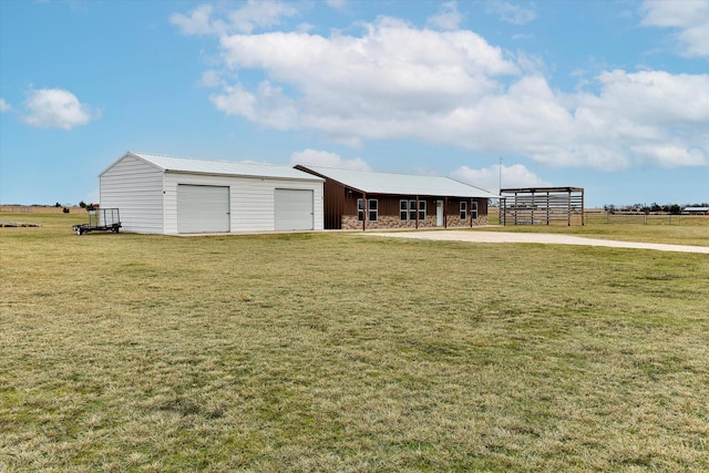 view of yard featuring a garage and an outbuilding