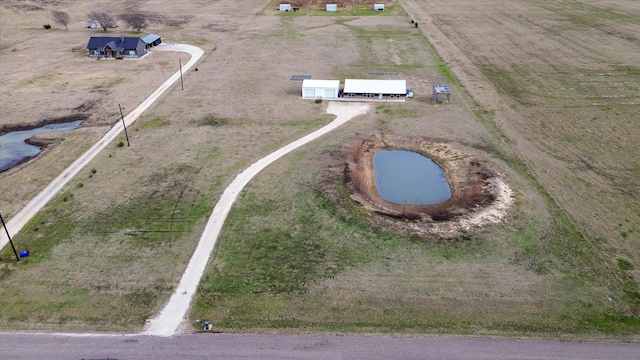 birds eye view of property featuring a water view and a rural view