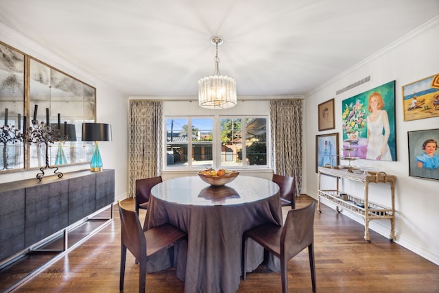 dining room with ornamental molding, dark wood-type flooring, and an inviting chandelier