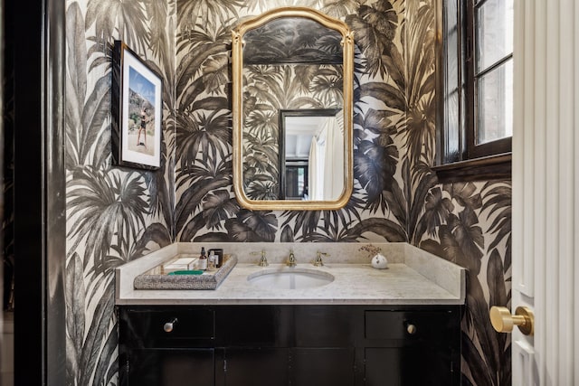 bathroom featuring vanity and wallpapered walls