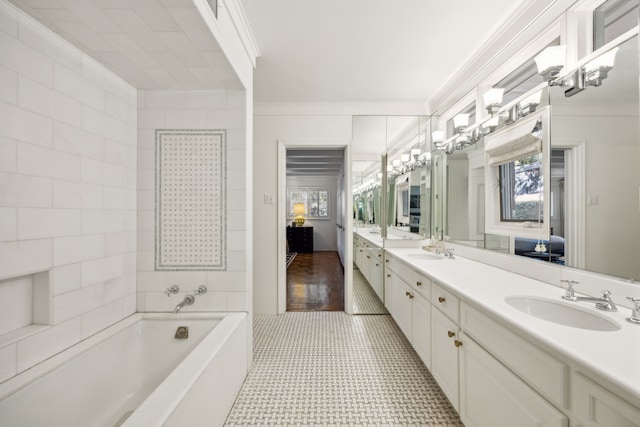 bathroom featuring vanity, tile patterned floors, ornamental molding, and a tub