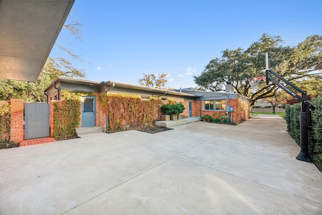 view of front facade featuring a gate and brick siding