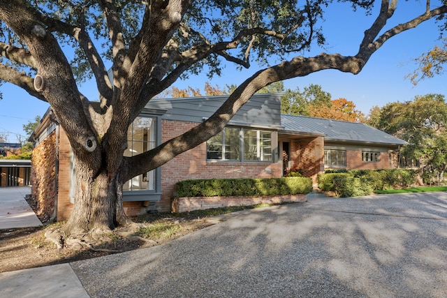 view of front of property featuring metal roof and brick siding