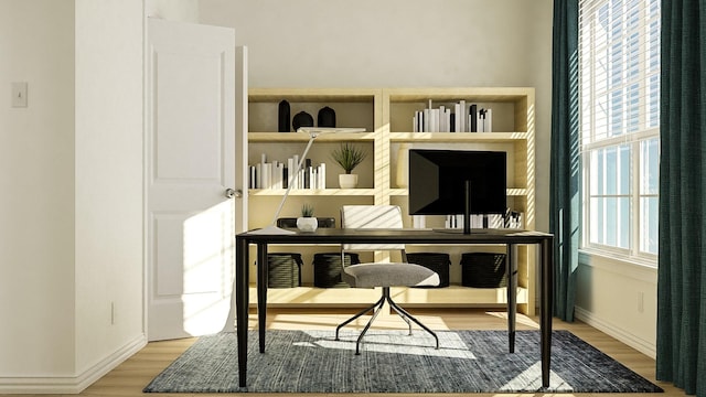 home office with wood-type flooring and a wealth of natural light