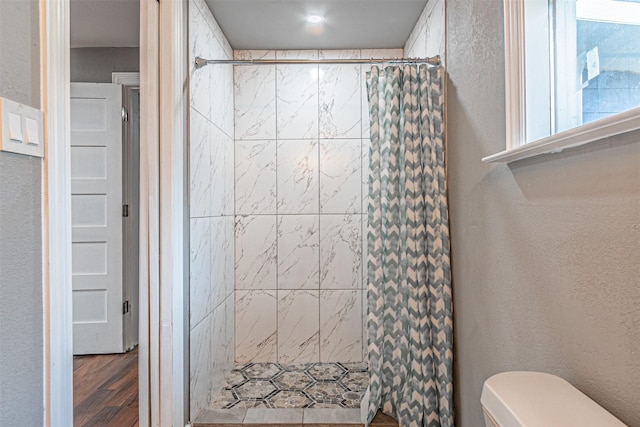 bathroom featuring hardwood / wood-style floors, a shower with curtain, and toilet