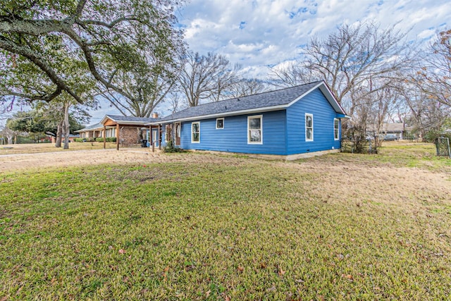 view of front of home with a carport and a front lawn