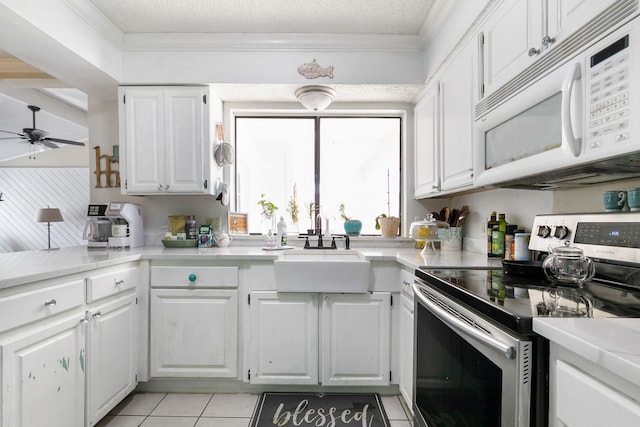 kitchen with electric stove, ceiling fan, light tile patterned floors, and white cabinets