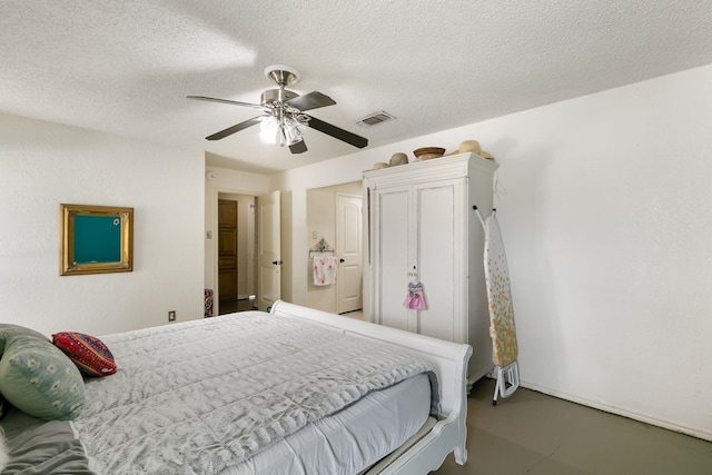 bedroom with ceiling fan and a textured ceiling