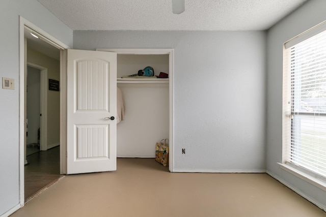 unfurnished bedroom with multiple windows, ceiling fan, a closet, and a textured ceiling