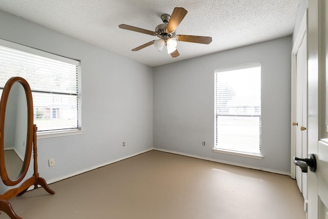 empty room with a textured ceiling and ceiling fan