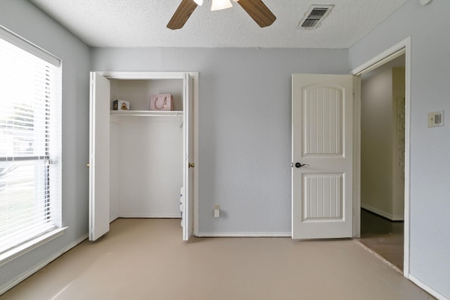 unfurnished bedroom featuring ceiling fan, multiple windows, and a textured ceiling