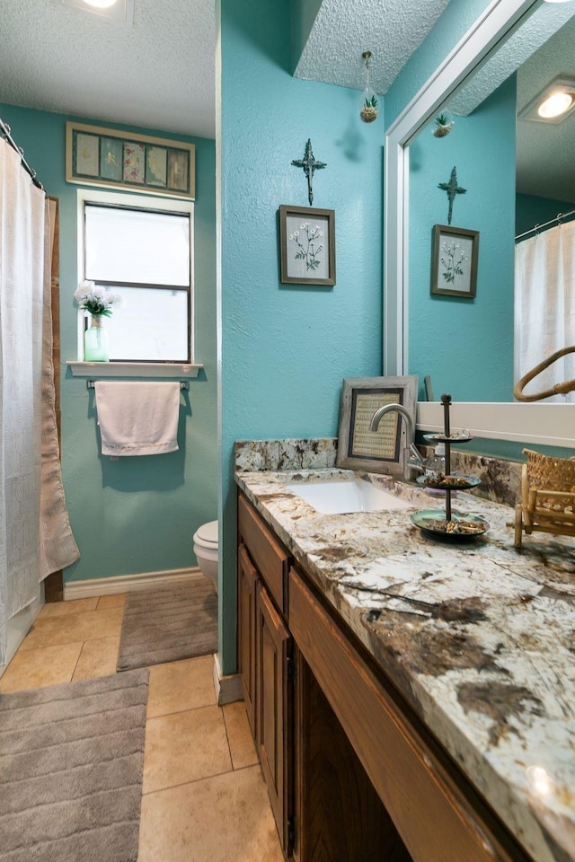 bathroom featuring tile patterned floors, toilet, a textured ceiling, and vanity