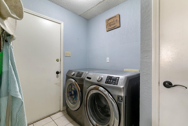 laundry area with washer and dryer and light tile patterned floors